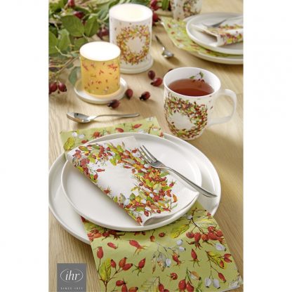 Bild von gedeckter Tafel mit Servietten und Kerze jeweils Druck von Hagebuttenkranz bzw. Hagebuttenzweigen