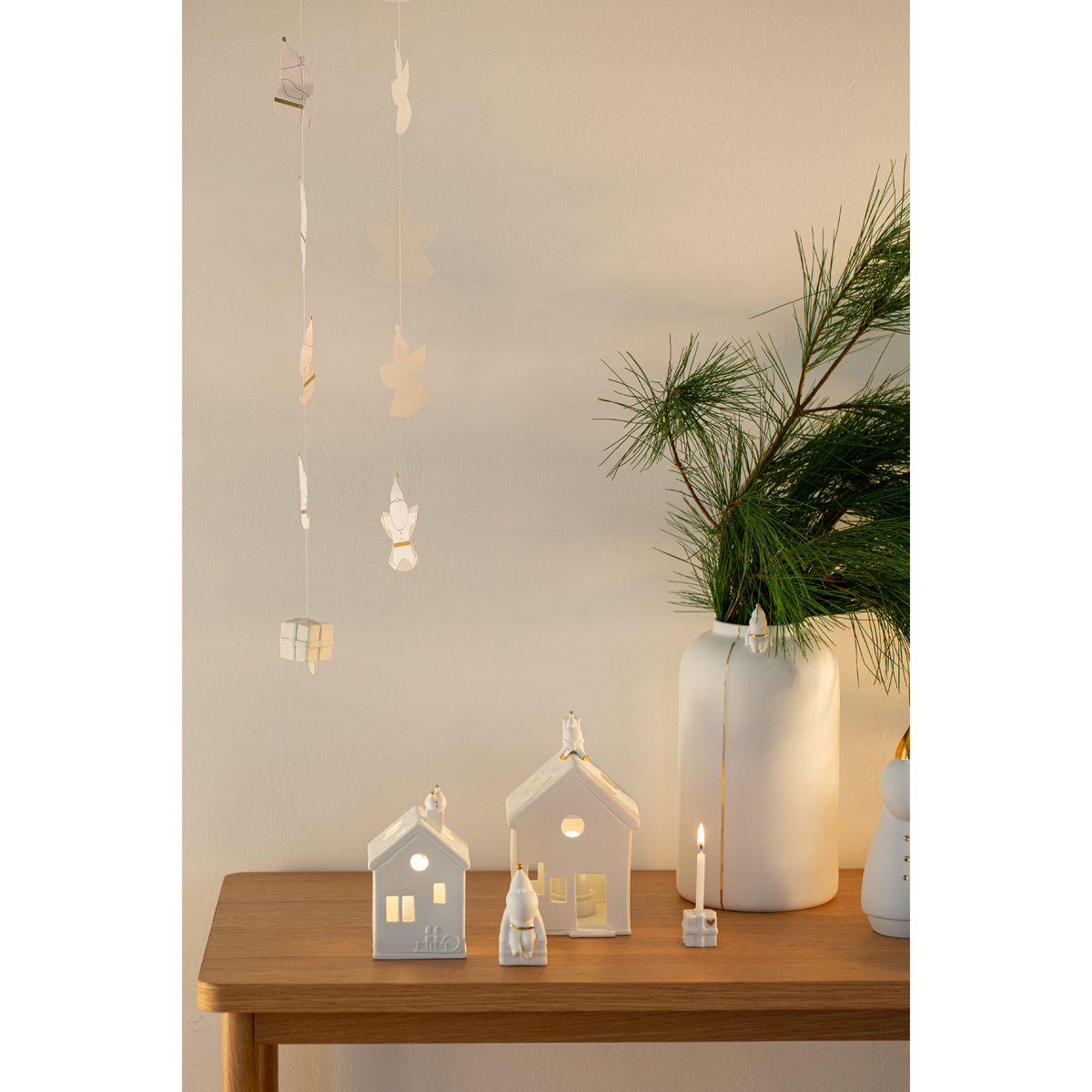 Tisch mit Dekoration der Lichthäuser Santa, Santa-Figur und einer VAse mit Tannengrün